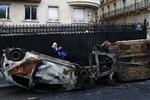 En kvinde fotograferer noget af resultatet af gårsdagens uro i Paris.  Foto: Thibault Camus/AP