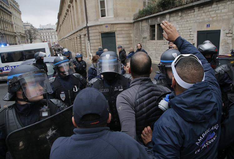 Paramedicinere overfor urobetjente mandag 3. december i Paris, mens premierminister Edouard Philippe holder krisemøde med repræsentanter for partirepræsentanter om de seneste tre ugers uro i Frankrig. 

   Foto: Michel Euler/AP