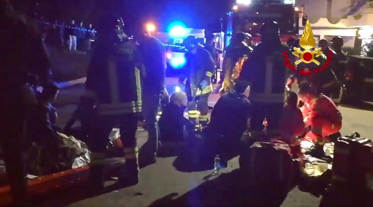 Redningshold hjælper sårede efter ulykken ved det italienske diskotek.

In this frame taken from video, rescuers assist injured people outside a nightclub in Corinaldo, central Italy, early Saturday, Dec. 8, 2018. At least Six people, all but one of them minors, were killed and about 35 others injured in a stampede of panicked concertgoers early Saturday at a disco in a small town on Italy's central Adriatic coast. (Vigili del Fuoco via AP) Foto: Vigili del Fuoco/AP