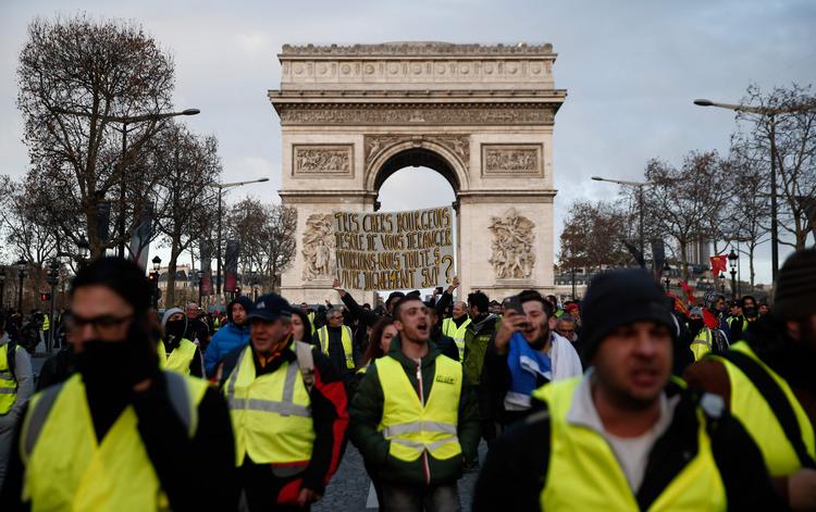 Demonstranter med de karakteristiske gule veste under Triumfbuen i Paris 8. december.       Foto: Abdul Abeissa/Ritzau Scanpix