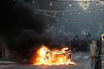 Demonstranter har sat ild til en bil under demonstrationer i lørdags i Frankrigs næststørste by Marseille. 
     Foto: Claude Paris/AP