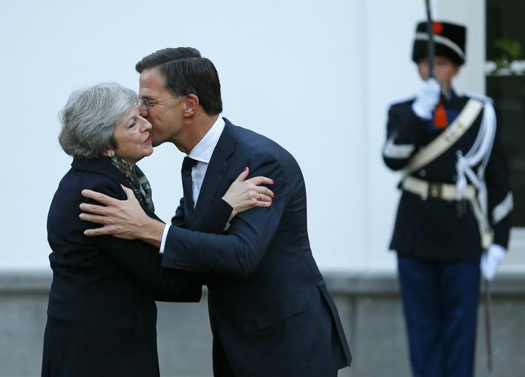 Theresa May blev mødt med kindkys af Hollands premierminister, Mark Rutte. Foto: Peter Dejong/AP
