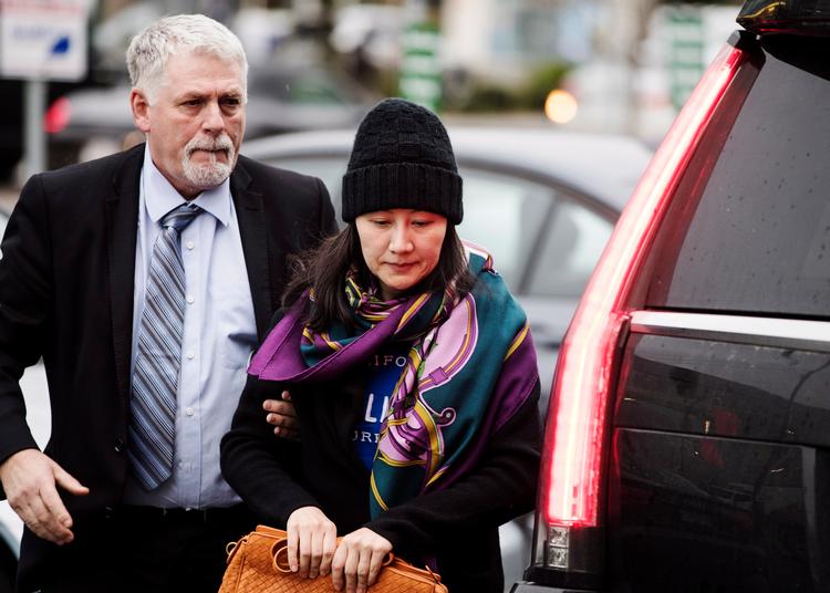 Huaweis finansdirektør, Meng Wanzhou, er ledsaget af en betjent, da hun ankommer til et myndighedskontor i  Vancouver, Canada.  Foto: Darryl Dyck/AP