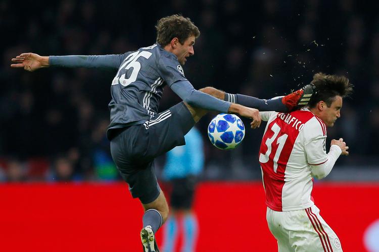 Denne 'tackling' på Nicolas Tagliafico kostede Thomas Müller et rødt kort, da Bayern og Ajax mødtes i aftes. 
   Foto: Peter Dejong/AP