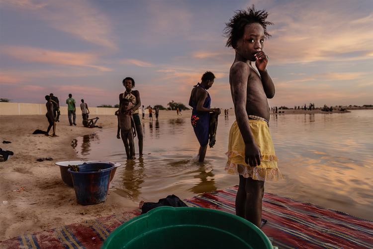 Beboerne i Timbuktu, Mali, vasker både dem selv og deres tøj, mens solen går ned over Kabara-havnen ved Niger-floden.  Foto: Stefano Pensotti/Travel Photographer of the Year
