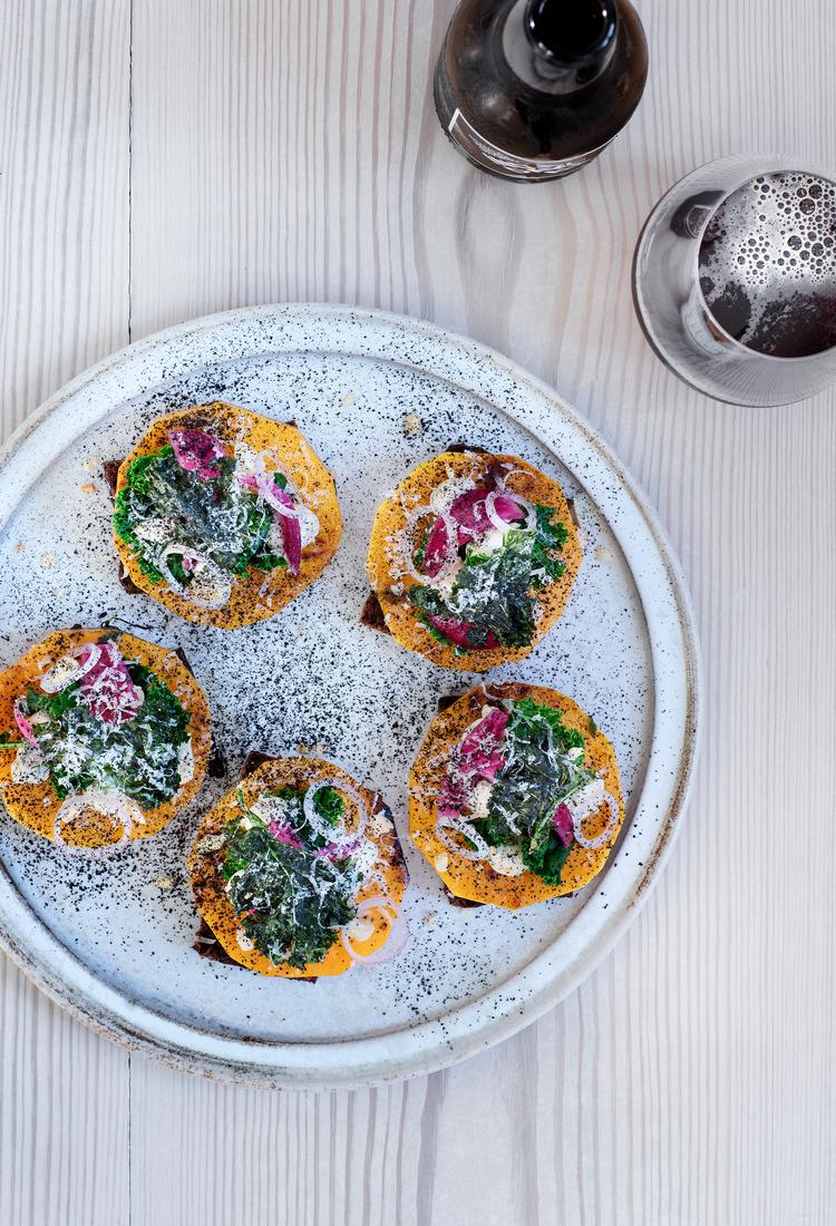 De runde skiver stegt butternut squash garneres med forskellig pynt, deriblandt ristede mandler. Foto: Line Thit Klein