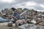 En overlever sidder ved sit hus efter tsunamien Foto: Fauzy Chaniago/AP