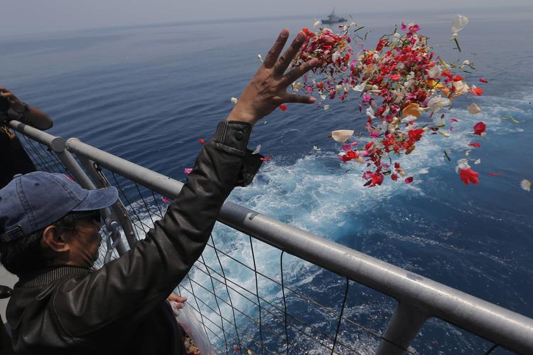 En efterladt smider blomster i havet, der hvor et Lion Air-passagerfly styrtede ned ved Indonesien sidste år.  Foto: Tatan Syuflana/AP