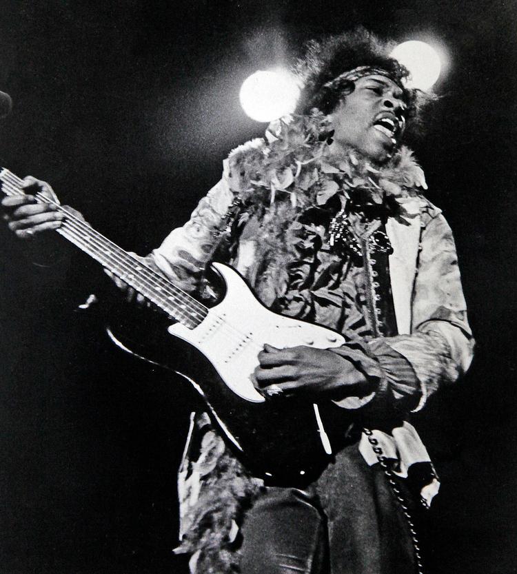 Jimi Hendrix fanget i et definerende øjeblik. Nemlig ved sin optræden på Monterey Pop festivalen i juni 1967. Koncerten sluttede med at Hendrix liggende på knæ, satte ild til sin guitar. Både mand og guitar var ellers allerede 'on fire'. Monterey Herald
   Foto: Monterey Herald/AP