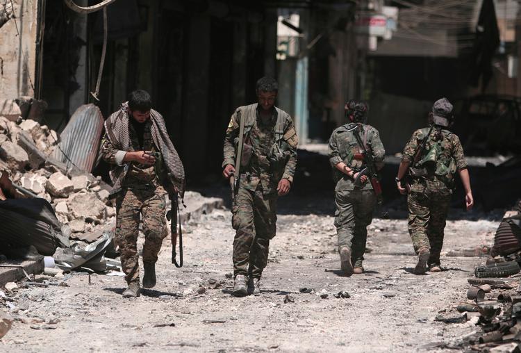Kæmpere fra Syriens Demokratiske Styrker ses her på gaden i Manbij i Aleppo-regionen.  Foto: Rodi Said/Ritzau Scanpix