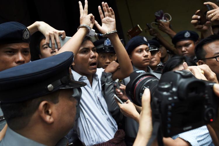 Journalist Kyaw Soe Oo eskorteres af politiket 3. september sidste år, efter han er blevet idømt en fængselsstraf på syv års fængsel. Han var sammen med en anden journalist, Wa Lone, i gang med at afdække et drab på ti mænd fra Myanmars rohingya-mindretal i Rakhine-delstaten, da de blev anholdt.   Foto: Ye Aung Thu/Ritzau Scanpix