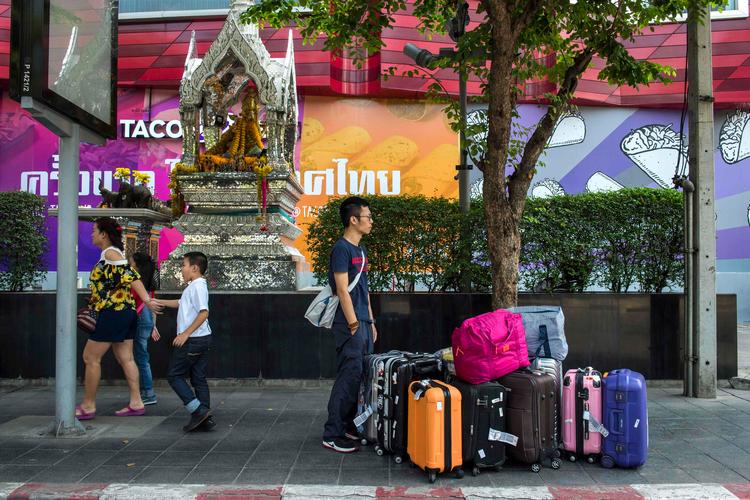 Kineserne kan nu rejse til 74 lande uden at skulle søge om visum. Her står en kinesisk turister med masser af kufferter på gaden i Bangkok.
    
   Foto: Romeo Gacad/Ritzau Scanpix/AFP