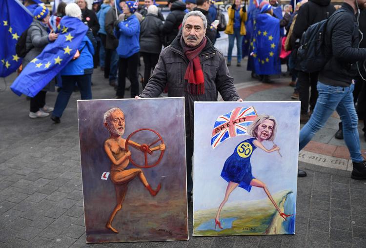 Den politiske satiretegner Kaya Mar med to af sine meget aktuelle figurer. Labours Jeremy Corbyn og den konservative premieminister, Theresa May.  Foto: Oli Scarff/Ritzau Scanpix