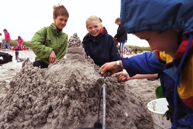 Lidt køligt vejr har aldrig holdt kække børn fra at besøge strandparken. Her ses nogle unge sandslot-bygmestre boltre sig i strandparken. Arkivfoto. Foto: Finn Frandsen/POLFOTO
