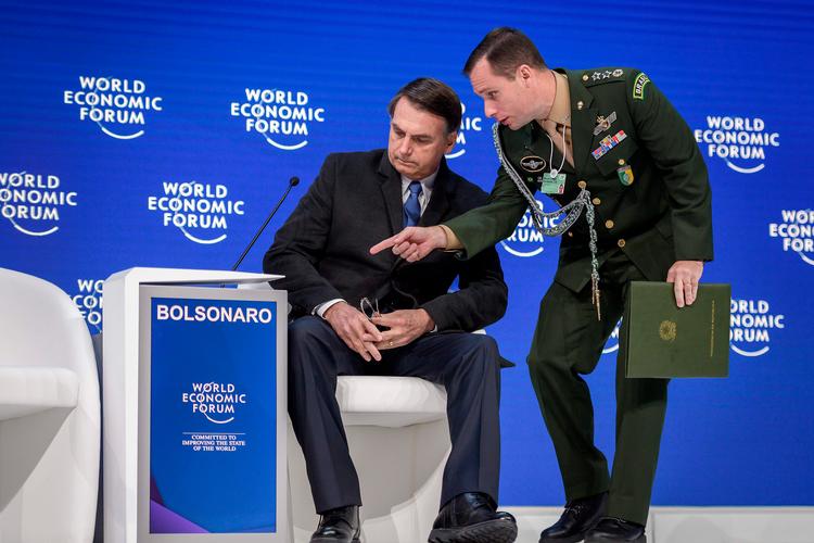 Brasiliens militærglade præsident, Jair Bolsonaro, fik hjælp af en officer ved topmødet i Davos.  Foto: Fabrice Coffrini, AfP. Foto: Fabrice Coffrini/Ritzau Scanpix
