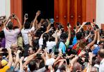 Venezuelanere tager billeder, da Juan Guaidó, der har udråbt sig selv om præsident, ankommer til en pressekonference i Caracas tidligere fredag.  Foto: Carlos Garcia Rawlins/Ritzau Scanpix