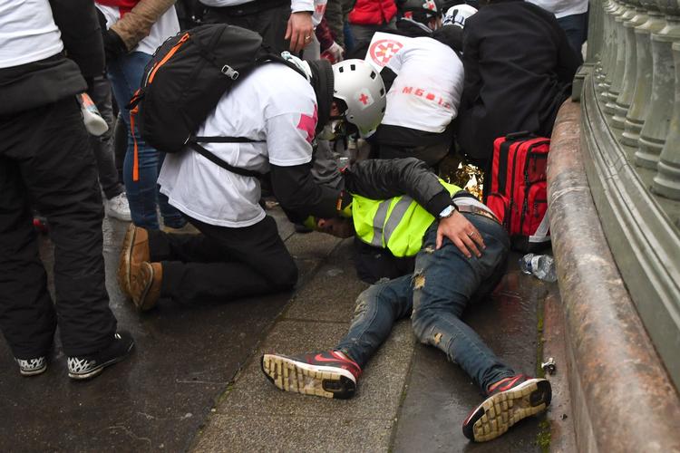 Såkaldte gadelæger behandler en demonstrant, som er kommet til skade.  Foto: Alain Jocard/Ritzau Scanpix