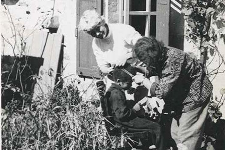 Venindebesøg. I det lille hus i landsbyen Oigny-en-Valois boede familien Ferlov Mancoba i 1950’erne. Planen var, at de skulle låne huset af veninden Clarisse Penso (.t.v) i et halvt år, men de blev hængende, indtil de to veninder havde et opgør, som afspejles i brevvekslingen. Fotoet er fra 1952, hvor Clarisse besøger familien og sønnen Wonga får klippet hår.  