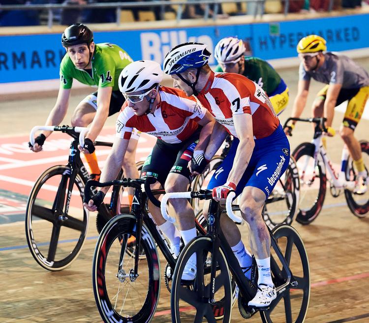 Michael Mørkøv dirigerer Oliver Wulff Frederiks videre på banelegemet, mens Jesper Mørkøv i baggrunden overvåger storebrors manøvrer. Foto: Lars Rønbøg/Bilka 6dagesløbet/Getty Images. 
