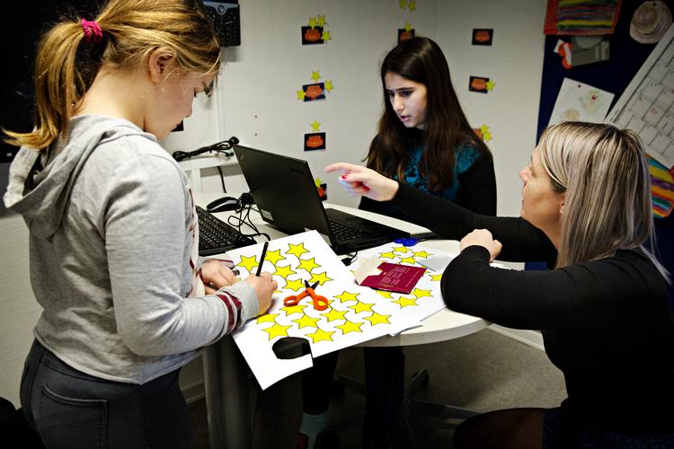 Brøker, plus, division og store tal. 3.d på Antvorskov Skole har matematik - i dag med et særligt program på computeren. Når de gennemfører et modul, må de klippe en stjerne ud, som hænges på væggen, forklarer lærer Mie Bang (th).  
   Foto: Martin Lehmann/POLFOTO