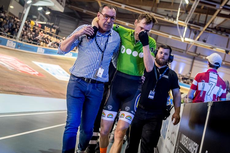En lidende Jesper Mørkøv hjælpes fra banen af seksdagesløbets læge Lars Juel Andersen.
 Foto: Mads Claus Rasmussen/Ritzau Scanpix