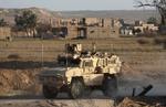 Et amerikansk militærkøretøj kører gennem en syrisk landsbyi den østlige provins Deir Ezzor for et par uger siden.   Foto: Delil Souleiman/Ritzau Scanpix