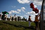 Ved hegnet til Marjory Stoneman Douglas High School står en række kors til minde om ofrene for skoleskyderiet, hvor 14 elever og tre ansatte blev skudt og dræbt. Det var en tidligere elev, som begik massakren for et år siden.  Foto: Carlos Garcia Rawlins/Ritzau Scanpix