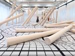 Claudia Comtes enorme installation 'I Have Grown Taller from Standing with Trees' korresponderer mønstret i gulvtæppet med den måde, de afbarkede stammer opfører sig på.  Foto: Copenhagen Contemporary