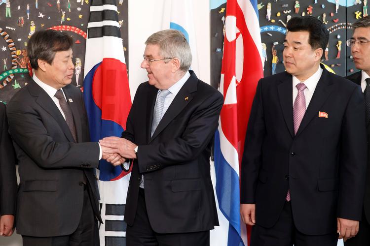 IOC-præsident Thomas Bach hilser fredag på Sykoreas sportsminister Do Jong-hwan, mens Nordkoreas olympiske leder Kim Il Guk ser til.  Foto: Pool/Ritzau Scanpix