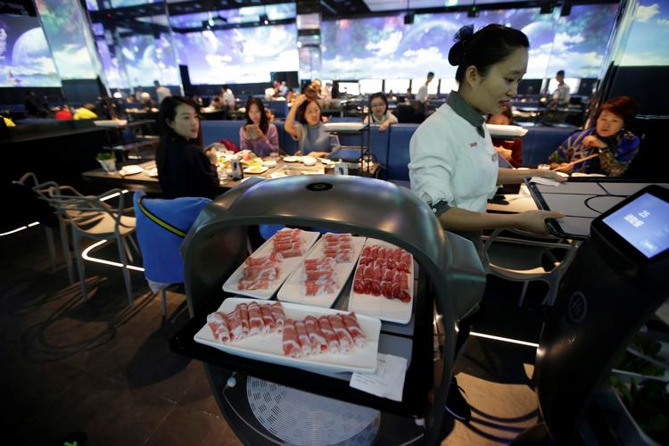 Robotter er en del af staben på Haidilao-restauranten i Beijing. De bruges mest i de områder, hvor gæsterne ikke kommer. 
   Foto: Jason Lee/Ritzau Scanpix