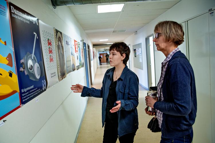 
Det er første gang, Sara Jacobsen (tv) designer en plakat, og hendes underviser Katarina Theiden (th) roser hendes brug af sværdet og gasmasken som kontrast mellem fortid og nutid.
   Foto: Jacob Ehrbahn/POLFOTO