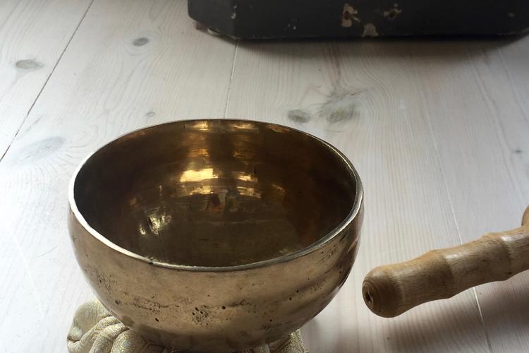 Christin Illeborg slår på skålen, der ringer som en klokke, når meditationen starter og slutter. Foto: Christina Alfthan