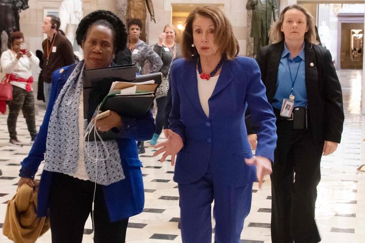 Demokraternes formand for Repræsentanternes Hus, Nancy Pelosi (i midten) og hendes partifælle Sheila Jackson Lee (tv.) på vej til at stemme Trumps nødret ned.  Foto: Jim Watson/Ritzau Scanpix