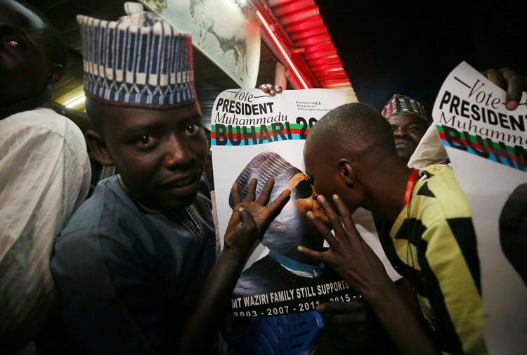 En tilfreds vælger kysser en valgplaket med et portræt af Nigerias genvalgte præsident, Muhammadu Buhari. Foto: Afolabi Sotunde/Ritzau Scanpix