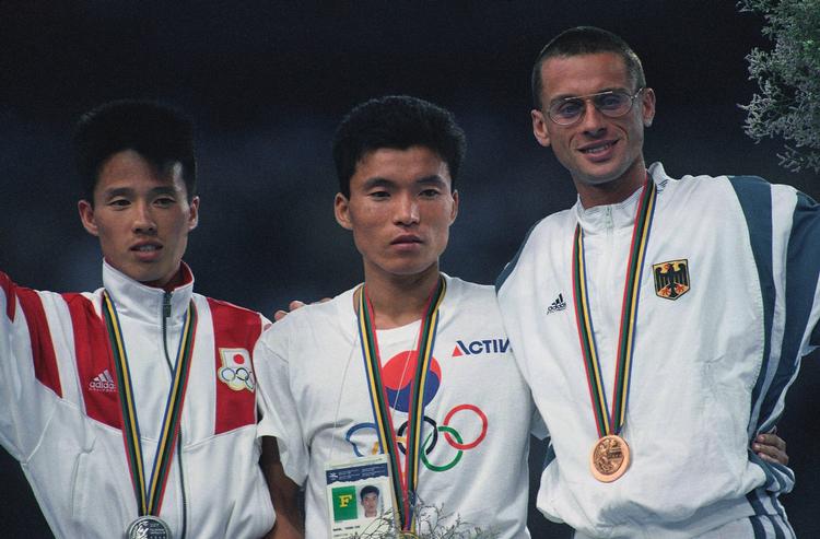 Sølvinder Koichi Morishita fra Japan (tv.) og den tyske braonzevinder Stephan Freigang flankerer den olympiske mester Young-Cho Hwangfra Sydkorea. Foto: Deither Endlicher/Ritzau Scanpix
