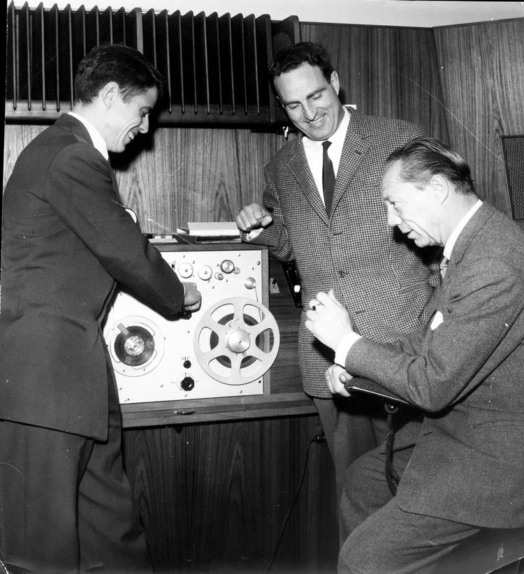 To berømte danske Hansen'er mødes i studiet i Danmarks Radio. Til højre er det ’stemmen’ Gunnar Nu Hansen, i midten er det fodboldspilleren John Hansen og til venstre en glad radiotekniker, hvis navn ikke er oplyst. Foto: Christen Hansen/POLFOTO