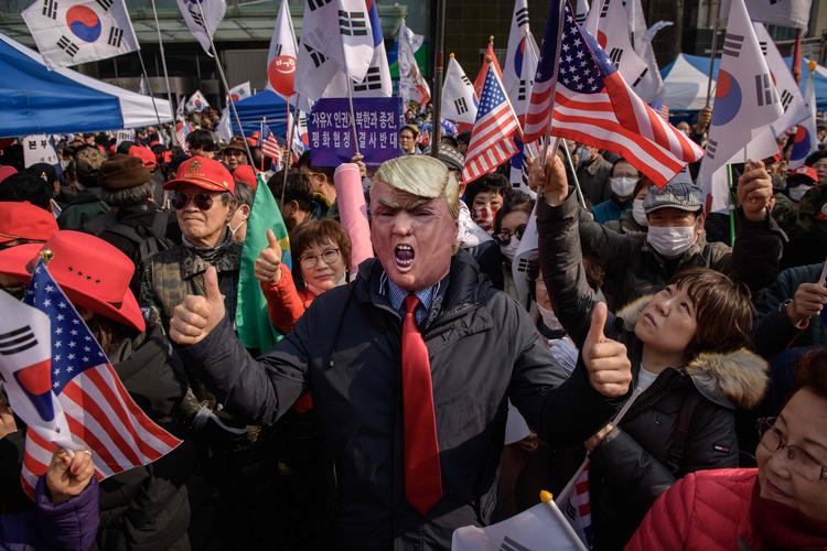 Under protester mod Nordkorea i Sydkoreas hovedstad, Seoul, i går, var flere iklædt Trump-masker eller kasketter.  Foto: Ed Jones/Ritzau Scanpix