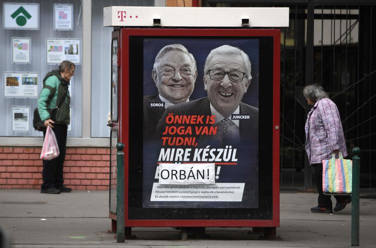 'I har ret til at vide, hvad Bruxelles pønser på', skrev Orbans parti på disse plakater med Juncker og Soros. Men Orban-kritikere ændrede Bruxelles til Orban. Nu kan det få konsekvenser for den ungarske regeringsleder.(Photo by ATTILA KISBENEDEK / AFP) Foto: Attila Kisbenedek/Ritzau Scanpix