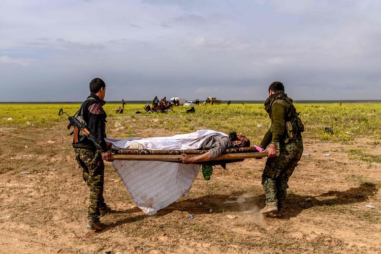 
    Soldater fra den kurdisk ledede Syrian Democratic Forces (SDF) bærer på en mand, som var mistænkt for at være IS-kriger. Foto: Bulent Kilic/Ritzau Scanpix