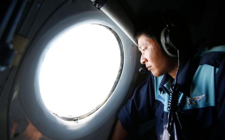 
En deltager i efterforskningen spejder ud gennem vinduet i et eftersøgningsfly over Det Indiske Ocean. Eftersøgningen blev indstillet i maj 2017. 
   Foto: Kham/Ritzau Scanpix