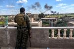 En soldat fra de syriske demokratiske styrker (SDF) betragter Islamisk Stat blive bombarderet med artilleri det østlige Syrien. Ifølge debattør Frida Ingeborg Tingberg Petersen har Danmark et juridisk ansvar for at hjemtage og retsforfølge de danskere, der er rejst til Mellemøsten for at kæmpe under terrorgruppens faner. 
   Foto: Bulent Kilic/Ritzau Scanpix