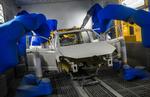 En bilkrop males af robotter på Volkswagens fabrik i Wolfsburg, Tyskland. Bilproducenten skærer ned i medarbejderstaben, oplyser den.   Foto: John Macdougall/Ritzau Scanpix