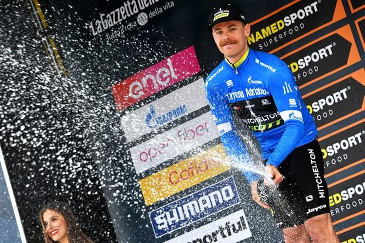 Indehaveren af den første førertrøje i Tirreno-Adriatico australieren Michael Hepburn optræder yderst sjældent ved podieseancerne på landevejen, men han havde ingen problemer med at håndtere flasken med de gyldne dråber. Foto: La Presser - D'Alberto/Ferrari. 