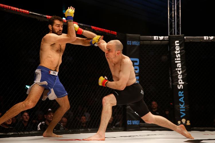 STEMNING. 2.500 højlydte tilskuere fyldte K.B. Hallen til et professionelt MMA-stævne. Man kunne bl.a. se den olympiske bryde-sølvvinder Mark O. Madsen (til højre)i kamp mod franskmanden Thibaud Larchet. Danske Madsen vandt. Foto: Finn Frandsen/POLFOTO