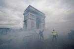 Triumfbuen i Paris blev lørdag indhyllet i røg, da politiet og demonstranter stødte sammen.  Foto: Philippe Wojazer/Ritzau Scanpix