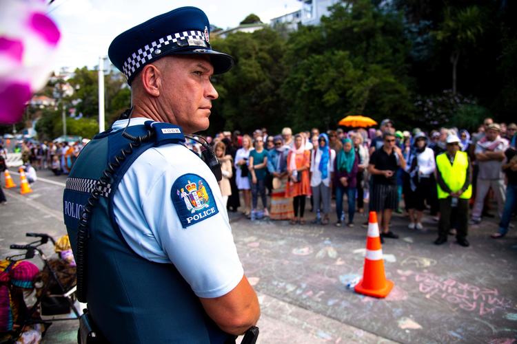 En betjent holder vagt ved et islamisk center i Wellington. Tusindvis samledes fredag for at mindes de døde i terrorangrebet for en uge siden i Christchurch.  Foto: Dave Lintott/Ritzau Scanpix