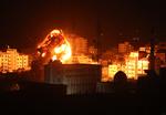 En ildkugle ses over Gaza by under israelske luftangreb få timer efter, at en raket fra den palæstinensiske enklave ramte ned i en  landsby langt inde i Israel.
     Foto: Majdi Fathi/AFP