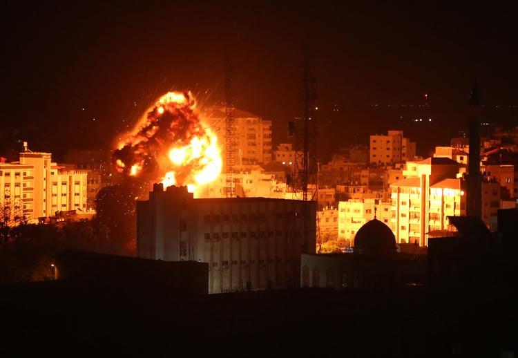 En ildkugle ses over Gaza by under israelske luftangreb få timer efter, at en raket fra den palæstinensiske enklave ramte ned i en  landsby langt inde i Israel.
     Foto: Majdi Fathi/AFP