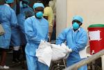 Medicinsk personale bærer liget af etn et-årig fra et center for vandbårne sygdomme i Beira, Mozambique, efter orkanen Idai. Foto: Mike Hutchings/Ritzau Scanpix