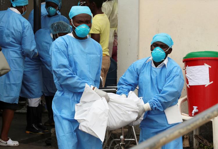 Medicinsk personale bærer liget af etn et-årig fra et center for vandbårne sygdomme i Beira, Mozambique, efter orkanen Idai. Foto: Mike Hutchings/Ritzau Scanpix